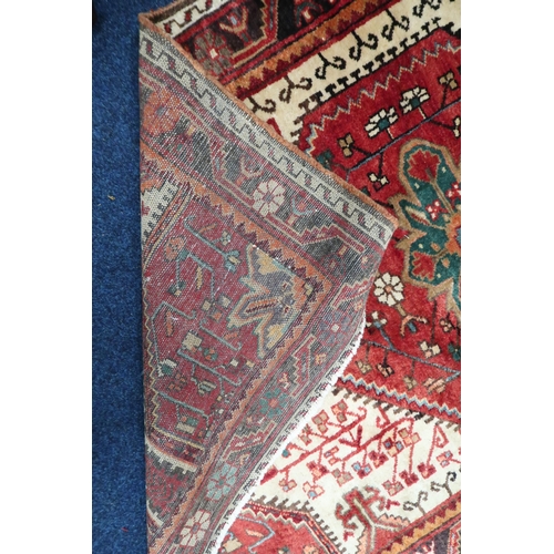 38 - A cream ground Hamadan rug with red central medallion and matching spandrels on geometric patterned ... 