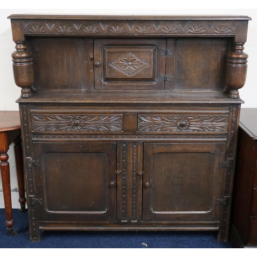 42 - A 20th century oak court style side cabinet with single door over two drawers over pair of cabinet d... 