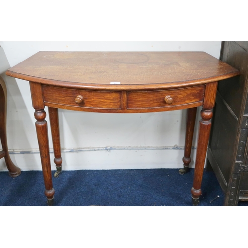 44 - An early 20th century oak bow fronted two drawer hall table on turned supports, 73cm high x 101cm wi... 