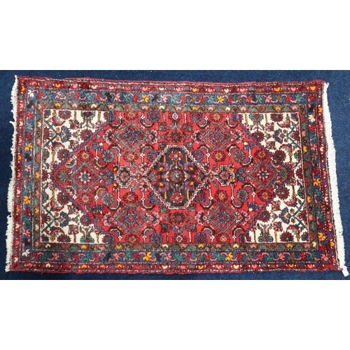 51 - A deep pile wool red ground Hamadan rug with dark central medallion and cream spandrels on geometric... 