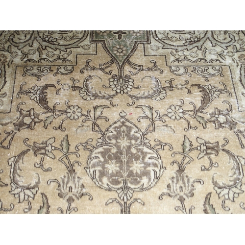 6 - A large beige ground Tabriz carpet with darker central medallion and spandrels on floral/foliate pat... 