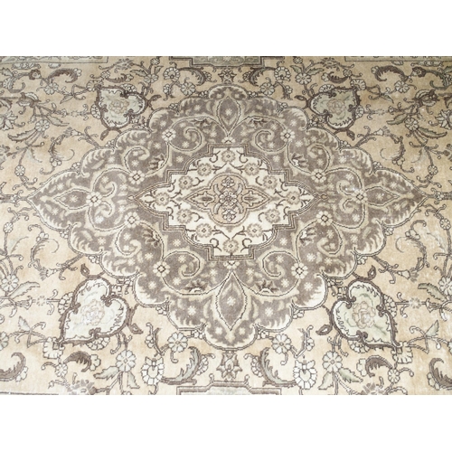 6 - A large beige ground Tabriz carpet with darker central medallion and spandrels on floral/foliate pat... 