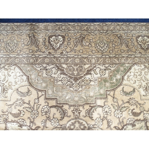 6 - A large beige ground Tabriz carpet with darker central medallion and spandrels on floral/foliate pat... 