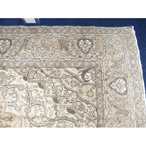 6 - A large beige ground Tabriz carpet with darker central medallion and spandrels on floral/foliate pat... 