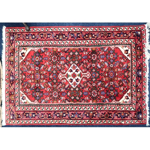 60 - A red ground Hamadan rug with cream central medallion and matching spandrels on multicoloured geomet... 