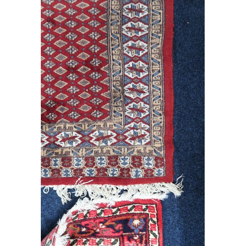 61 - A red ground Araak rug with geometric patterned ground within multicoloured lozenge patterned border... 