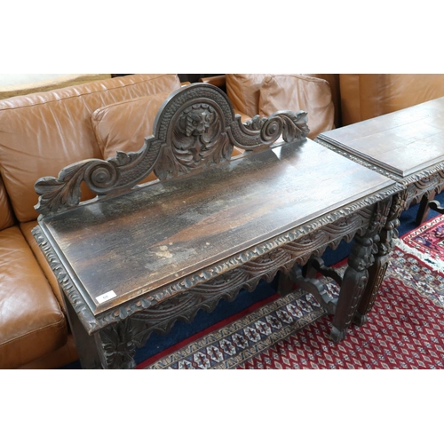 68 - A pair of 19th century carved oak hall tables, the larger with carved foliate back splash over gadro... 