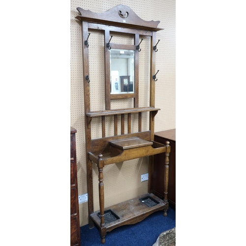 8 - A 20th century oak mirror backed hall stand with central bevelled glass mirror pane flanked by coat ... 