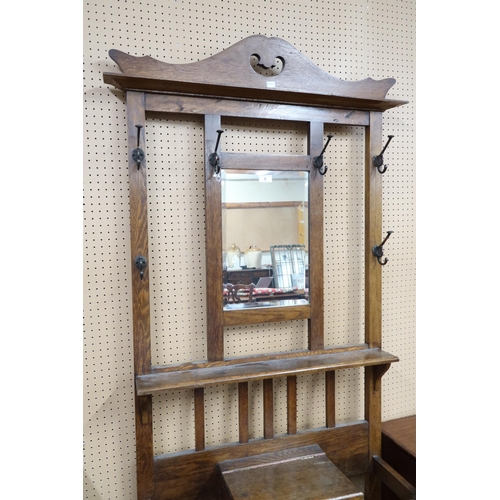 8 - A 20th century oak mirror backed hall stand with central bevelled glass mirror pane flanked by coat ... 