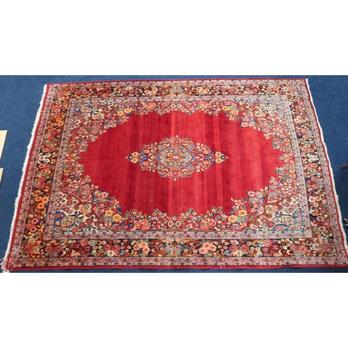 86 - A deep red ground Bijar rug with multicoloured floral pattern central medallion and spandrels within... 