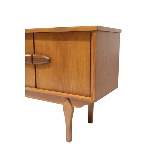 2105A - A MID 20TH CENTURY TEAK JENTIQUE SIDEBOARDWith fall front drinks cabinet flanked by cabinet doors al... 