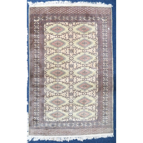 137 - An ivory ground Turkoman rug with all-over diamond lozenge design within geometric patterned border,... 