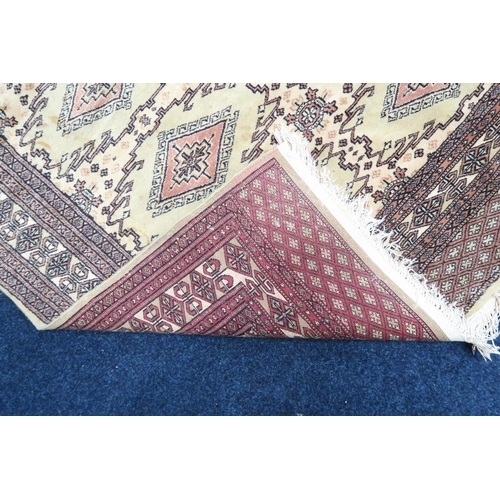 137 - An ivory ground Turkoman rug with all-over diamond lozenge design within geometric patterned border,... 