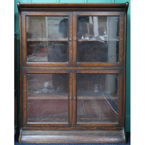 5 - An early 20th century oak two tier sectional bookcase with two pairs of glazed doors on shaped plint... 