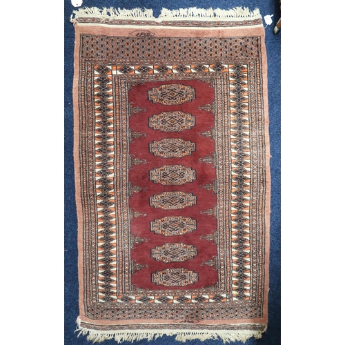 67 - A red ground Bokhara rug with multicoloured lozenge ground within geometric border, 157cm long x 96c... 