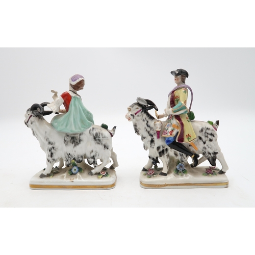 212 - A pair of porcelain figures of Count Bruhl's Tailor and Wife, both modelled seated on the back of go... 