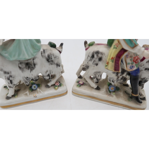 212 - A pair of porcelain figures of Count Bruhl's Tailor and Wife, both modelled seated on the back of go... 