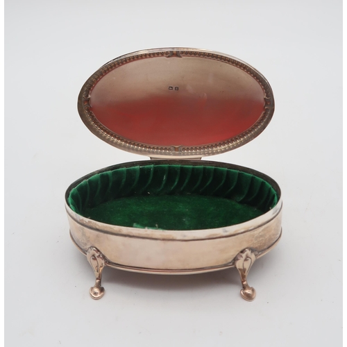 357 - A George V silver jewellery box, by Henry Matthews, Birmingham 1917,  of oval form, on four pad... 