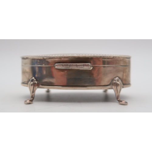 357 - A George V silver jewellery box, by Henry Matthews, Birmingham 1917,  of oval form, on four pad... 