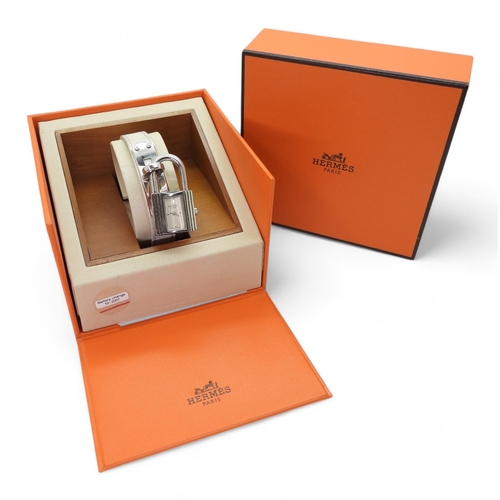 A ladies Hermes Kelly watch, number KE1.210, issue number 2059285 with white leather strap, original box and receipt from Harrods, circa 2008.