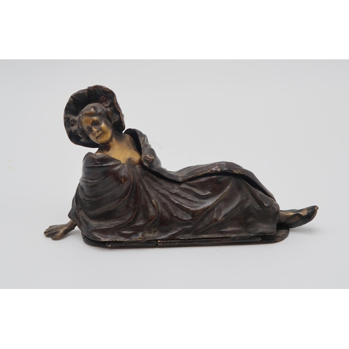 217 - A 20th century after Bergman cold painted bronze figurine of a reclining scantily clad lady, with a ... 