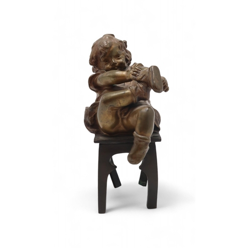 220 - Juan Clara Ayats (1875 -1958) A bronze of a young girl on chair, putting on her shoes