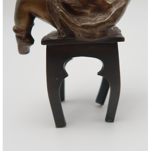 220 - Juan Clara Ayats (1875 -1958) A bronze of a young girl on chair, putting on her shoes