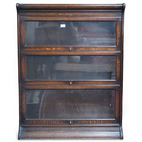 An early 20th century after Globe Wernicke oak three tier sectional bookcase with glazed doors on shaped plinth base, 112cm high x 87cm wide x 30cm deep