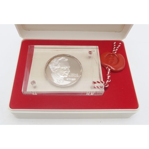 551B - A Leica Oskar Barnack Award medal, presented within a Perspex block, with wax seal suspended, housed... 