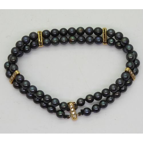 2704 - A BLACK PEARL & DIAMOND BRACELETthe double row of black pearls is interspaced with 18ct gold bat... 