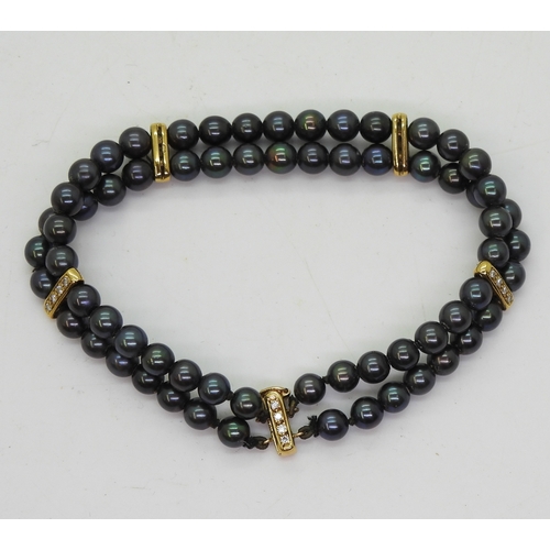 2704 - A BLACK PEARL & DIAMOND BRACELETthe double row of black pearls is interspaced with 18ct gold bat... 