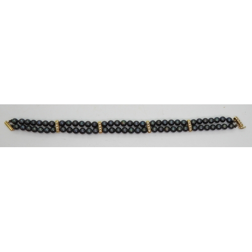 2704 - A BLACK PEARL & DIAMOND BRACELETthe double row of black pearls is interspaced with 18ct gold bat... 