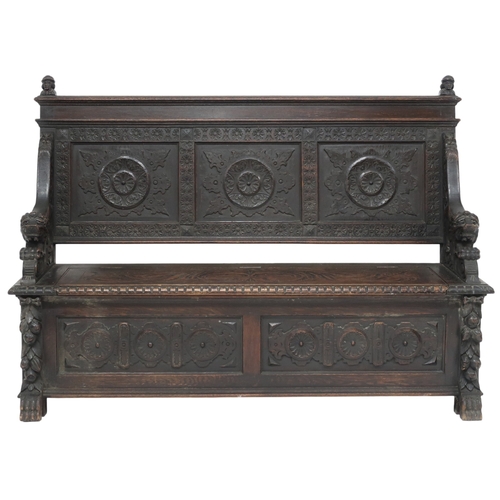 2001 - A 19TH CENTURY STAINED OAK GOTHIC STYLE SETTLE panel back carved with circular reliefs capped with t... 