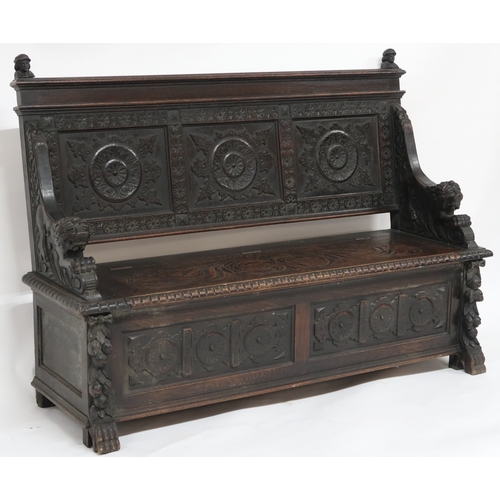 2001 - A 19TH CENTURY STAINED OAK GOTHIC STYLE SETTLE panel back carved with circular reliefs capped with t... 