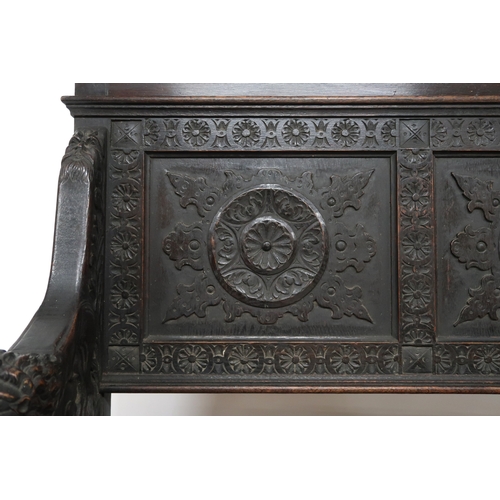 2001 - A 19TH CENTURY STAINED OAK GOTHIC STYLE SETTLE panel back carved with circular reliefs capped with t... 