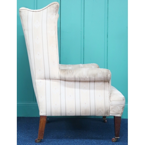 2009 - AN EDWARDIAN WINGBACK ARMCHAIR with shaped wingback over scrolled arms on square tapering supports t... 