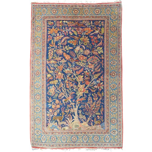 2150 - A DARK BLUE GROUND TREE OF LIFE PATTERNED RUG with multicoloured stylistic animals and birds amongst... 