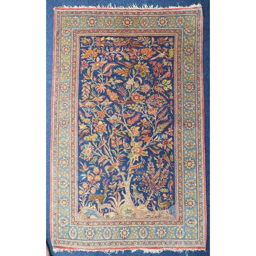 2150 - A DARK BLUE GROUND TREE OF LIFE PATTERNED RUG with multicoloured stylistic animals and birds amongst... 