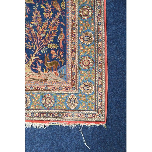 2150 - A DARK BLUE GROUND TREE OF LIFE PATTERNED RUG with multicoloured stylistic animals and birds amongst... 