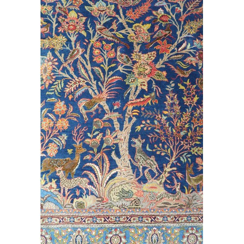 2150 - A DARK BLUE GROUND TREE OF LIFE PATTERNED RUG with multicoloured stylistic animals and birds amongst... 