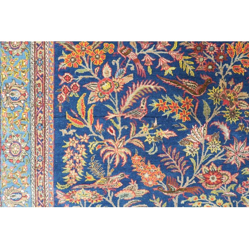 2150 - A DARK BLUE GROUND TREE OF LIFE PATTERNED RUG with multicoloured stylistic animals and birds amongst... 