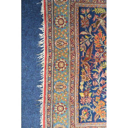 2150 - A DARK BLUE GROUND TREE OF LIFE PATTERNED RUG with multicoloured stylistic animals and birds amongst... 