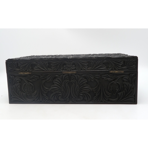 2213 - A 19TH CENTURY CARVED EBONY WRITING BOXcarved all over with scrolling foliage and pomegranates, 42cm... 