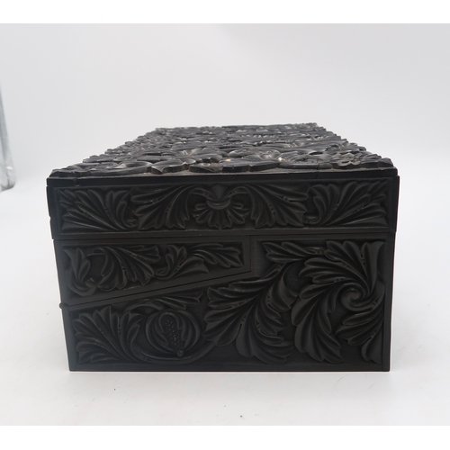 2213 - A 19TH CENTURY CARVED EBONY WRITING BOXcarved all over with scrolling foliage and pomegranates, 42cm... 