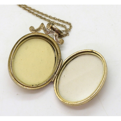 769 - A decorative locket, the yellow metal locket is engraved with a star to the front, set with split pe... 