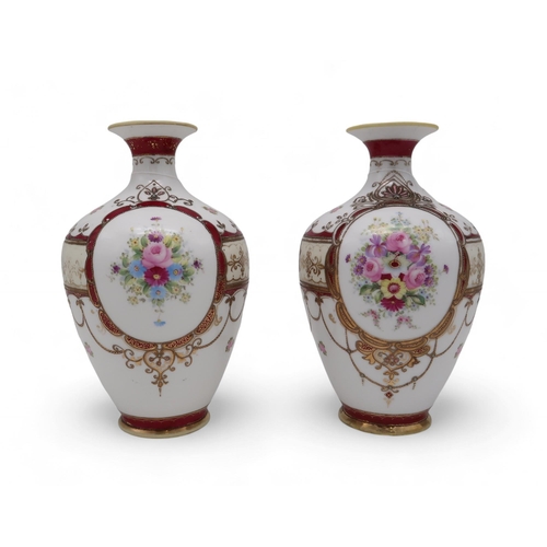 205 - A pair of Noritake vases, each painted with a bouquet of flowers within raised gilt borders