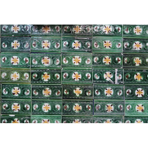 224 - A collection of half tiles, with tube line decoration of daffodils on a cream and green ground (76)