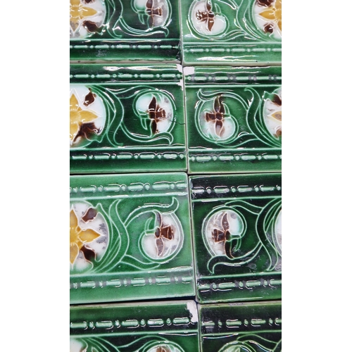 224 - A collection of half tiles, with tube line decoration of daffodils on a cream and green ground (76)