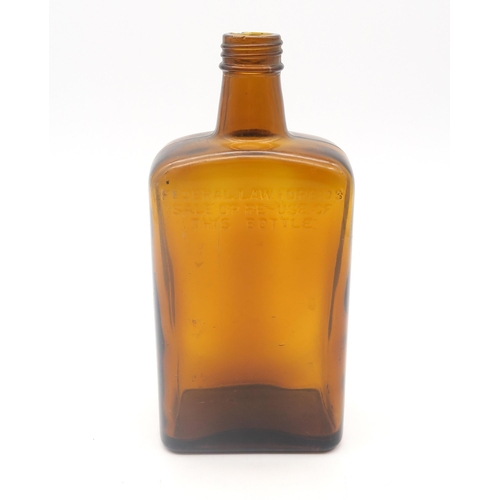 A Ballantyne's whisky bottle reputedly recovered from the wreck of the S.S. Politician (the inspiration for the novel and subsequent film Whisky Galore!), circa-1941; the amber moulded glass bottle reading "Federal law forbids sale or re-issue of this bottle" upon front face and "Geo. Ballantyne &  Son Ltd. Glasgow Scotland Bottle Made in Great Britain" upon base, standing approx. 22cm in height