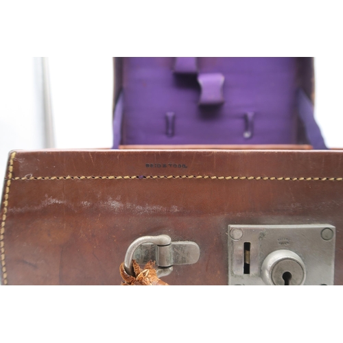 511 - A small tan leather travel case by Reid & Todd of Glasgow; with contents to include a black lacq... 